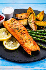 Grilled salmon with baked potatoes, asparagus and vegetable salad