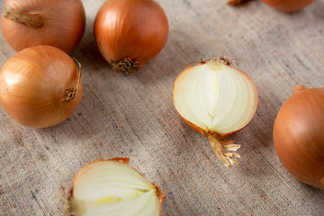Unpeeled raw yellow onions on cloth, low angle view. Closeup.