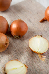 Unpeeled raw yellow onions on cloth, low angle view. Close-up.