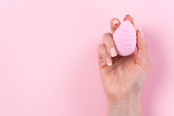 Hand holding cosmetic sponge