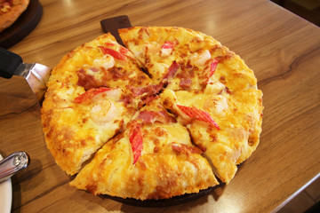 pizza served at restaurant on handled wooden board