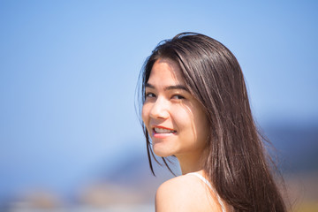 Beautiful teen girl at beach on sunny day, smiling