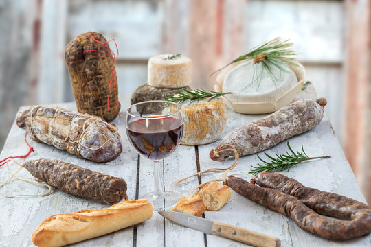 Corsican wild pork delicatessen, and cheese made in Corsica France on wooden background with glass of red corsican wine