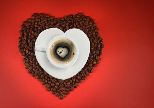 image of cup of coffee and coffee beans on red background