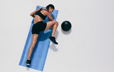 Fitness woman doing push ups on a yoga mat