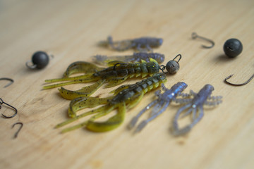 Colorful silicone fishing baits with plummets on wooden table. Various fish and worms and crayfish. Toned image and top view. Stock background, photo