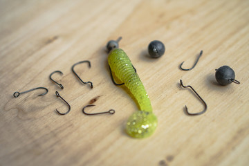 Colorful silicone fishing baits with plummets on wooden table. Various fish and worms and crayfish. Toned image and top view. Stock background, photo
