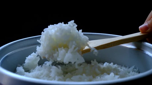 cooked rice steaming  with hand scooping rice concept 