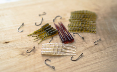 Colorful silicone fishing baits with plummets on wooden table. Various fish and worms and crayfish. Toned image and top view. Stock background, photo