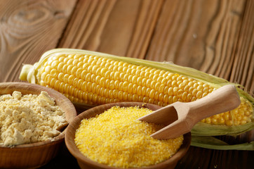 Bowl of corn grits corncob and corn flour on kitchen table