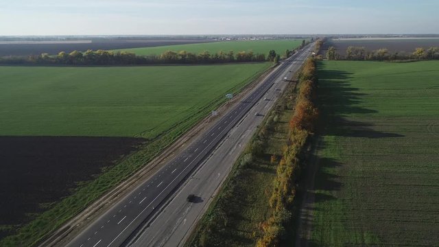 Aerial view of the auto road Kiev-Odessa with one repaired strip and the other with an old strip with holes and patches. Beautiful countryside in autumn