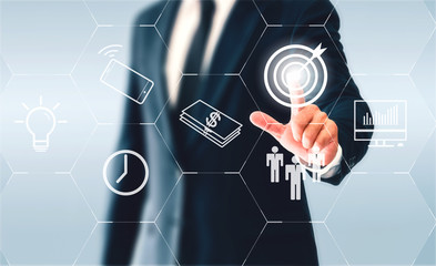 Businessman touching hexagonal button goal. The goal was to make a business success.