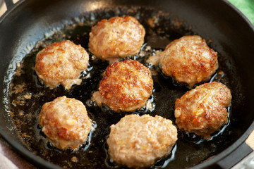 Cutlets are fried in a pan. Beef and pork cutlets are fried in a cast-iron pan. Meat dish in the cooking process. Meat patties in oil.