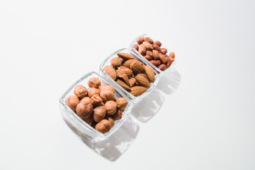 Peanuts, hazelnuts and almonds on a white background