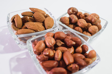 Peanuts, hazelnuts and almonds on a white background