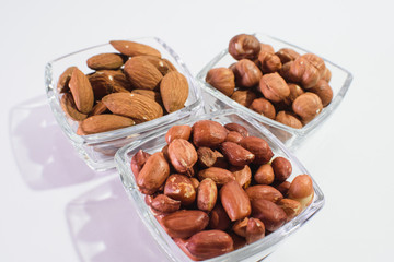 Peanuts, hazelnuts and almonds on a white background