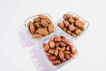Peanuts, hazelnuts and almonds on a white background