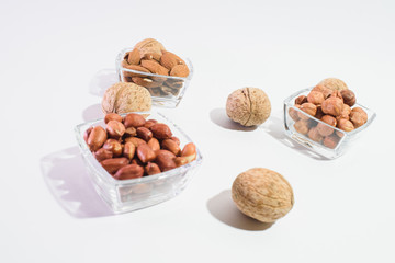 Peanuts, hazelnuts, almonds and walnuts on a white background