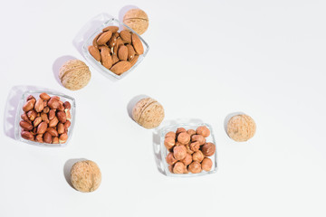 Peanuts, hazelnuts, almonds and walnuts on a white background