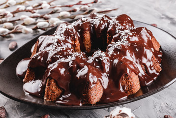 Easter cake with chocolate, coconut, spring flowers on a stone background. Happy Easter celebration