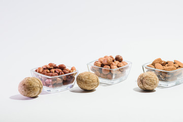 Peanuts, hazelnuts, almonds and walnuts on a white background
