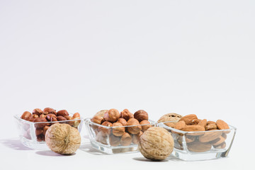 Peanuts, hazelnuts, almonds and walnuts on a white background