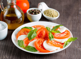 Close-up photo of caprese salad with ripe tomatoes, basil, buffalo mozzarella cheese. Italian and Mediterranean food concept. Fresh and healthy organic meal. Starter and antipasti. 