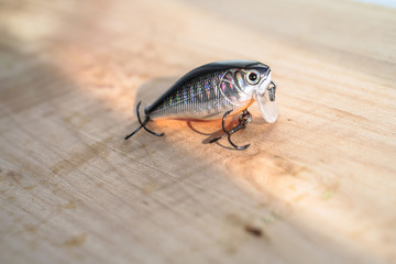 Colorful fishing baits with plummets on wooden table. Wobbler on a wooden board with beautiful...