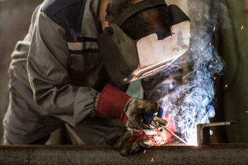 Industrial worker cutting metal at the factory