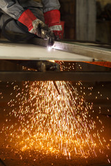 Industrial worker cutting metal at the factory