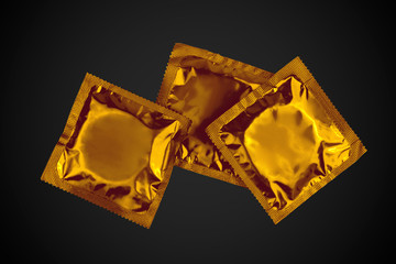 Gold condoms to black background