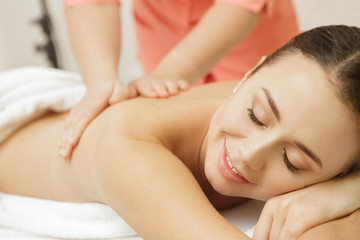 Fototapeta na wymiar Beautiful female client enjoying full body massage at the spa salon
