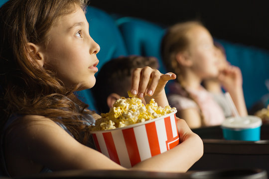 Group of happy kids enjoying a movie at the cinema