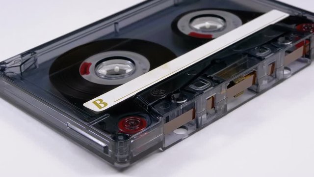 Transparent Audio Cassette Rotates on White Background