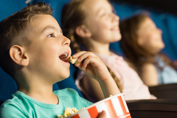 Group of happy kids enjoying a movie at the cinema
