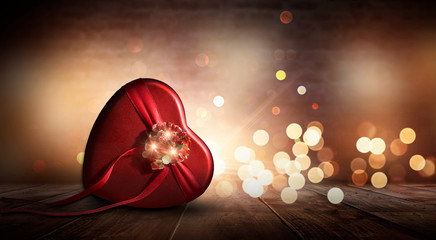 Romantic background with flowers, red roses and a box, a heart-shaped box. Night lanterns, bokeh lights magical atmosphere of the evening. The scenery is romance. Love stories for women. Night view