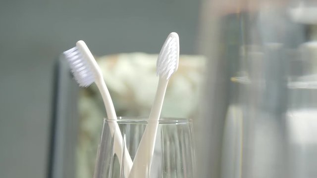 closeup with toothbrush in glass in bathroom