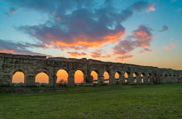 Rome (Italy) - The Parco degli Acquedotti at sunset, an archeological public park in Rome, part of the Appian Way Regional Park, with monumental ruins of roman aqueducts. - obrazy, fototapety, plakaty
