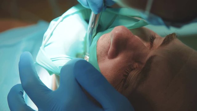 Dentist treating a patient using cofferdam. 4K