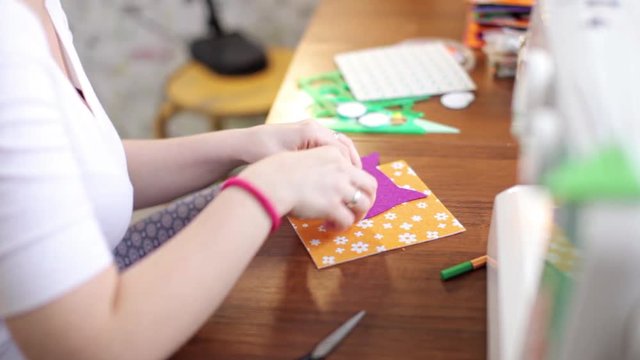 woman crafting colorful felt book
