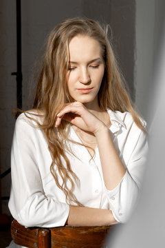 Sad thoughtful model looking down in white shirt
