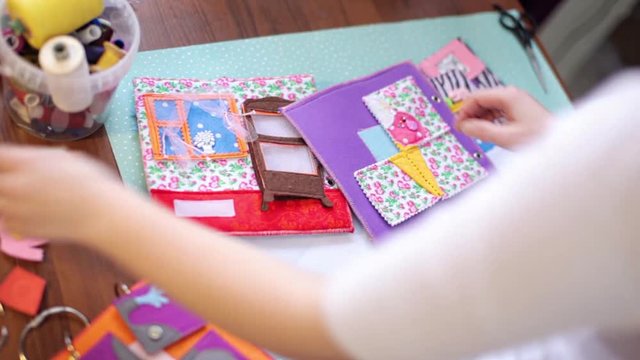 woman crafting colorful felt book