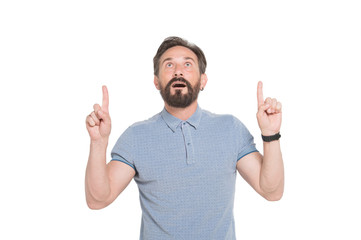 Naklejka premium Amazed bearded man pointing his fingers up and keeping his mouth opened