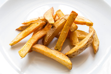 appetizing fried potato pieces with garlic and salt, with white sauce on a plate