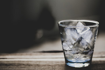 Ice in a glass, placed on a wooden table