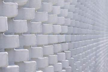 White brick wall in unusual pattern with bricks sticking out - selective focus