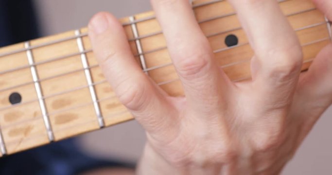 Musician playing electric guitar, fretboard close-up