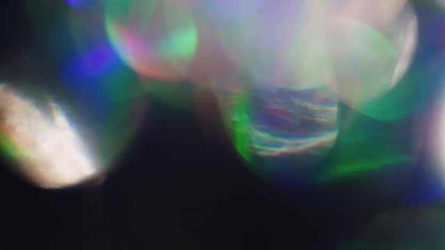 Abstract background iridescent holoraphic foil vibrant bokeh in the dark.