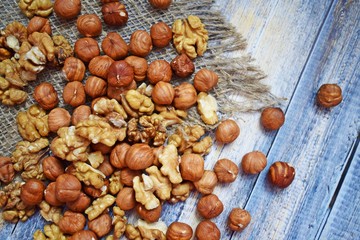 Delicious and healthy nuts on burlap, on a wooden background.