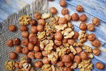 Delicious and healthy nuts on burlap, on a wooden background.